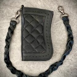 Portefeuille cuir quilting losange vue de face Portefeuille biker cuir à quilting losange vu de face, lanière tressée et mousquetons métal